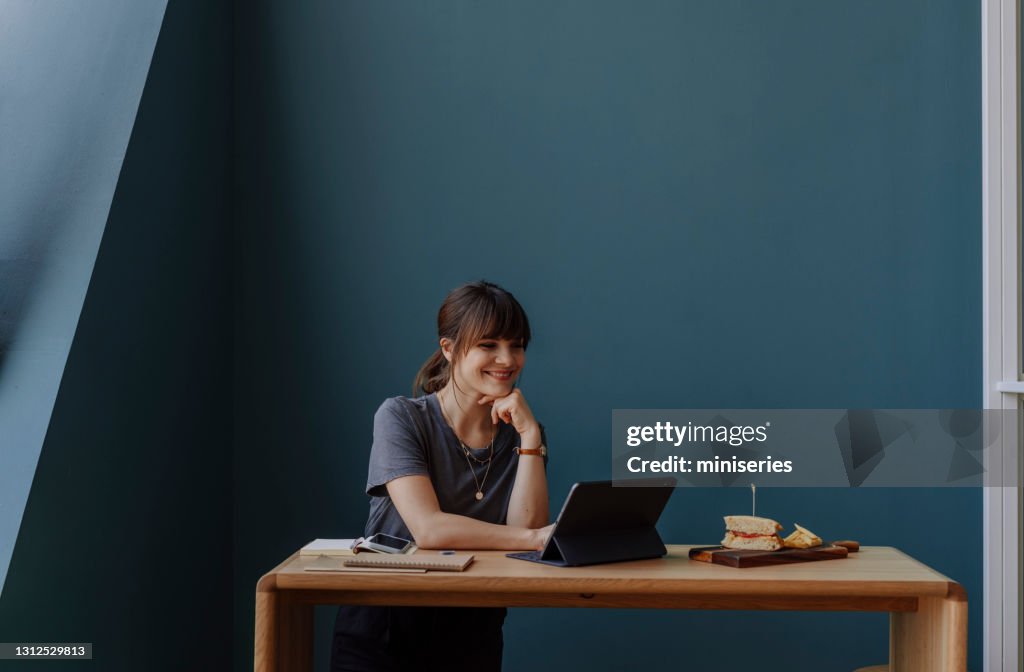 Beautiful Happy Businesswoman Surfing the Net on her Digital Tablet During the Lunch Break (Copy Space)