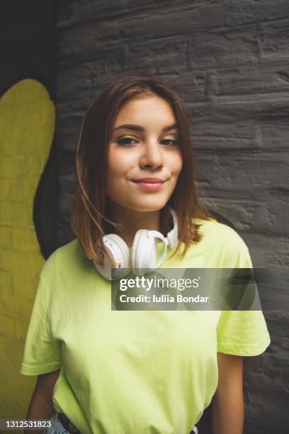 hipster girl with headphones at the wall - hipster girl stock-fotos und bilder