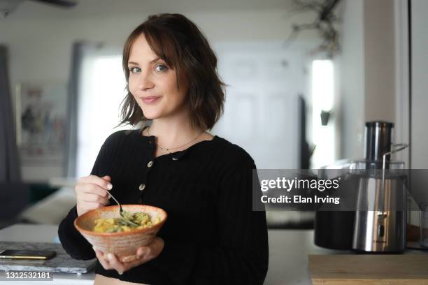 woman eating a plant-based diet - soup on spoon stock pictures, royalty-free photos & images