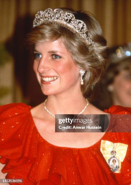 Diana, Princess of Wales, wearing a red dress designed by Bruce Oldfield, the Spencer Tiara and the Royal Family Order of the Queen and the Prince of...