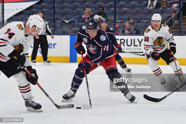 Carl Soderberg of the Chicago Blackhawks and Max Domi of the Columbus Blue Jackets reach for a loose puck during the second period of a game at...