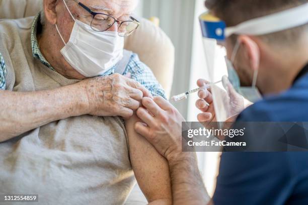 senior getting the covid-19 vaccine - aged care vaccine stock pictures, royalty-free photos & images