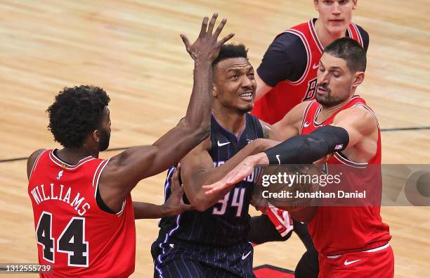 Nikola Vucevic of the Chicago Bulls knocks the ball away from Wendell Carter Jr. #34 of the Orlando Magic as Carter tries to drive between Vucevic...