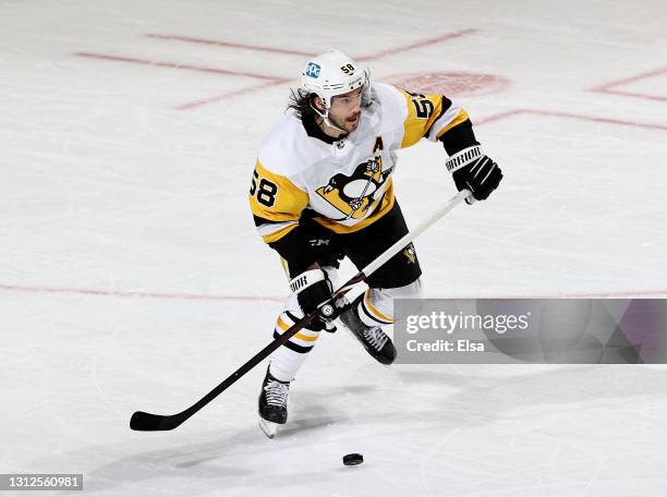 Kris Letang of the Pittsburgh Penguins takes the puck in the third period against the New Jersey Devils at Prudential Center on April 09, 2021 in...