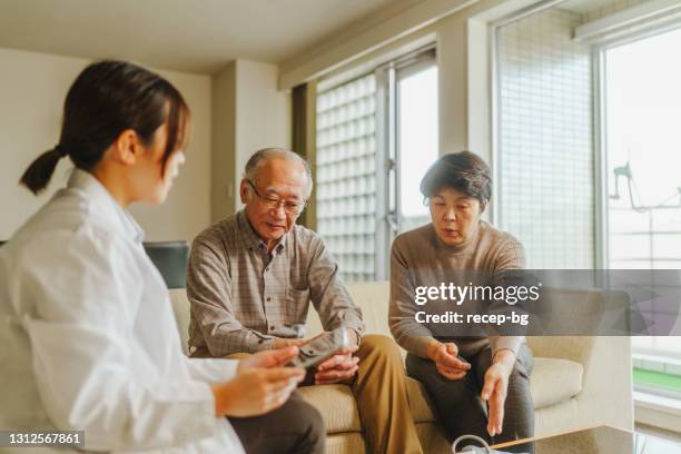 female doctor home visiting senior patients at their home - house call stock pictures, royalty-free photos & images