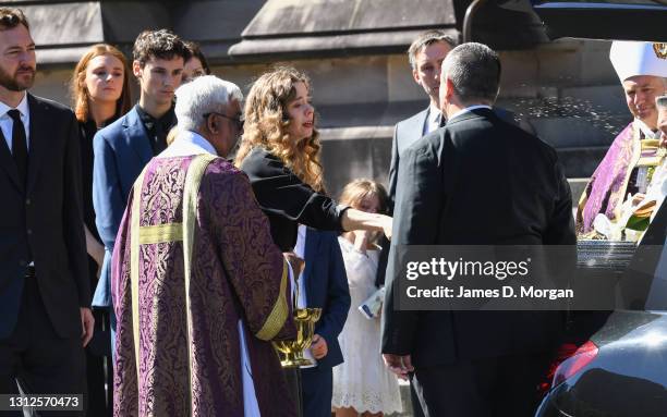 Bianca Spender, daughter of Carla Zampatti puts water onto her mother's coffin as the hearse prepares to depart at the State Funeral for Carla...