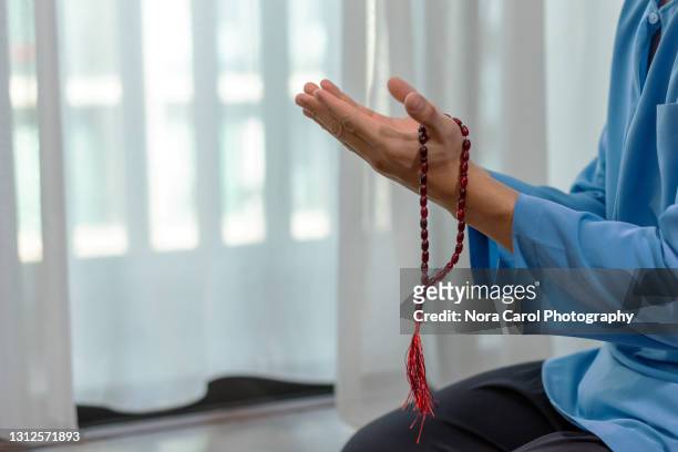 close up of hands praying with praying beads - namaz stock pictures, royalty-free photos & images