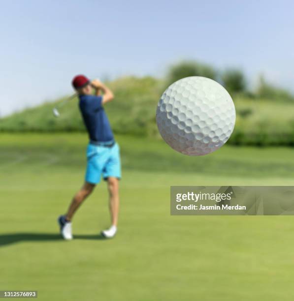 man playing golf at club hitting the ball - golf stock-fotos und bilder