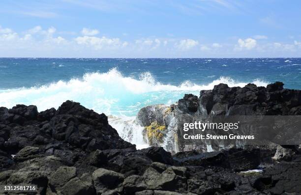 the pacific ocean breaks upon black lava rock - ocean waves crashing into lava rock stockfoto's en -beelden