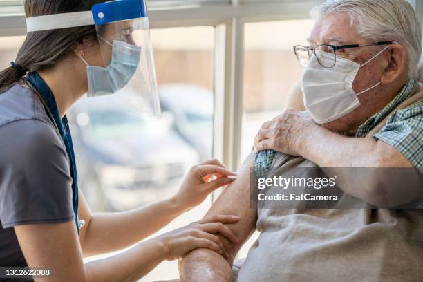 senior getting the covid-19 vaccine - aged care vaccine stock pictures, royalty-free photos & images