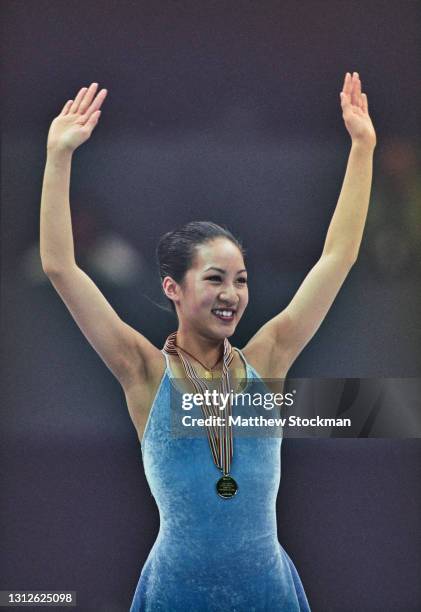 Michelle Kwan of the United States raises her arms aloft to celebrate winning the gold medal in the Ladies Figure Skating Singles competition during...