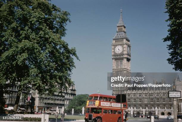 London Transport number 3 double decker RT bus bound for Camden Town drives around Parliament Square with the Clock Tower , Big Ben and the Houses of...