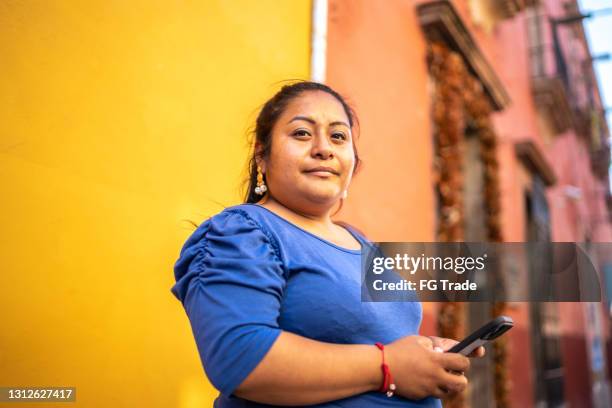 jonge vrouw in openlucht die smartphone met behulp van - colombiaanse etniciteit stockfoto's en -beelden