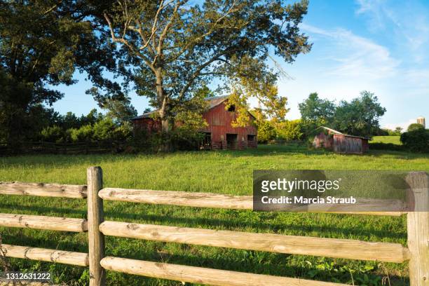 a red barn in the midwest usa - sprossenzaun stock-fotos und bilder