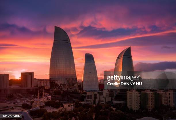 flame tower under dramatic sky at dusk - azerbaijan stock-fotos und bilder