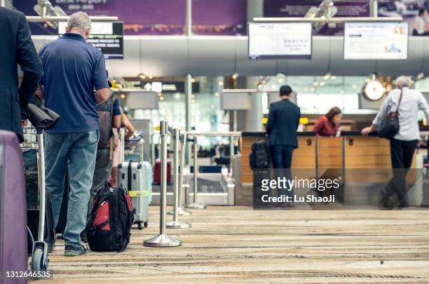 passengers lined up at the airport to check in their luggage. - 搭乗手続き ストックフォトと画像