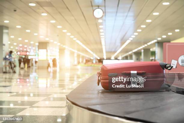 luggage on conveyor belt at airport - airport luggage fotografías e imágenes de stock