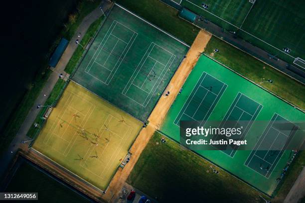 a drone view onto sports pitches illuminated at night - calcio a 5 foto e immagini stock