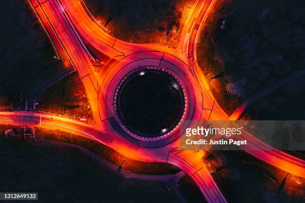 drone view of a roundabout illuminated at night - drone aerial stock-fotos und bilder