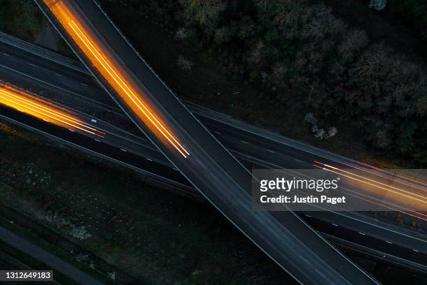 drone view of cars moving in different directions at night - straßenverkehr stock-fotos und bilder