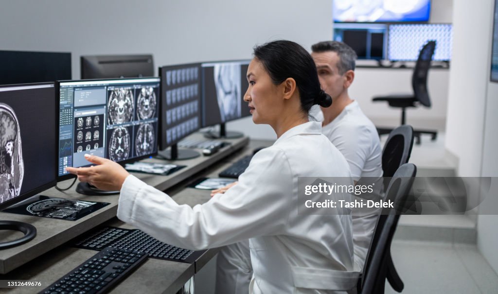 Two Radiologists Looking At Mri Scan On Computer High-Res Stock Photo ...