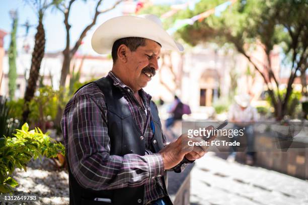 senior man using smartphone outdoors - mexican mustache stock pictures, royalty-free photos & images
