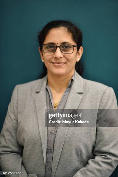 formal portrait of a woman wearing blazer against blue background - indian corporate women background stockfoto's en -beelden