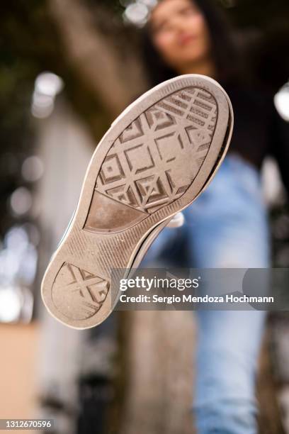 young latino woman stepping on camera, low angle pov of camera - sole of shoe stock pictures, royalty-free photos & images