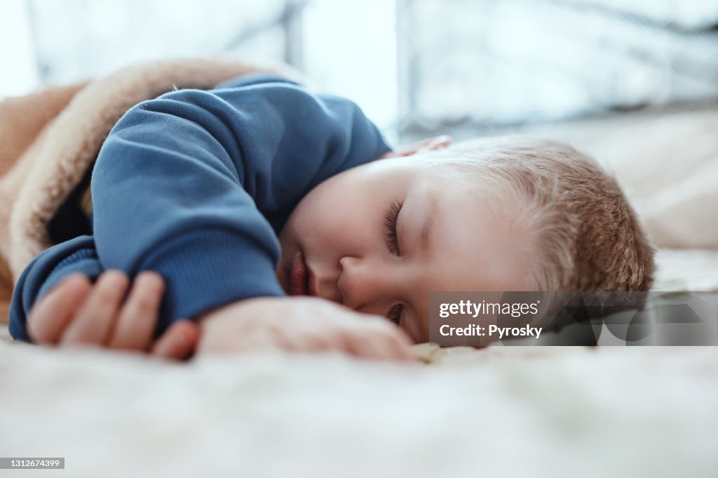 Un adorable niño de dos años tomando una siesta