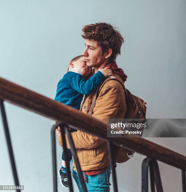 samen tijd doorbrengen - father holding sleeping baby stockfoto's en -beelden