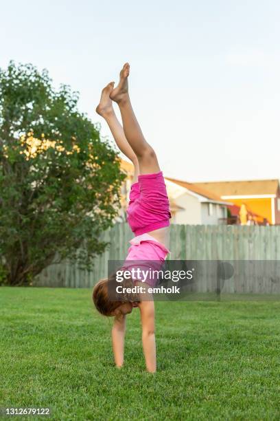 chica haciendo la mano de pie en el patio trasero - hacer el pino fotografías e imágenes de stock