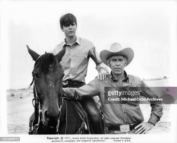 Ted Eccles on horse while James Coburn stands close in a scene from the film 'The Honkers', 1972.