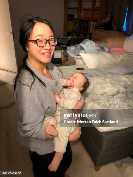 a chinese mom cuddling her sleeping baby - tired mother stock pictures, royalty-free photos & images