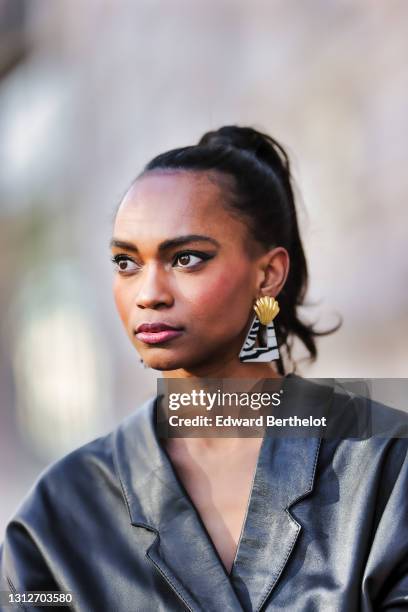 Emilie Joseph @in_fashionwetrust wears a vintage soft leather oversized shirt, zebra earrings with golden parts from Rixo London, on April 15, 2021...