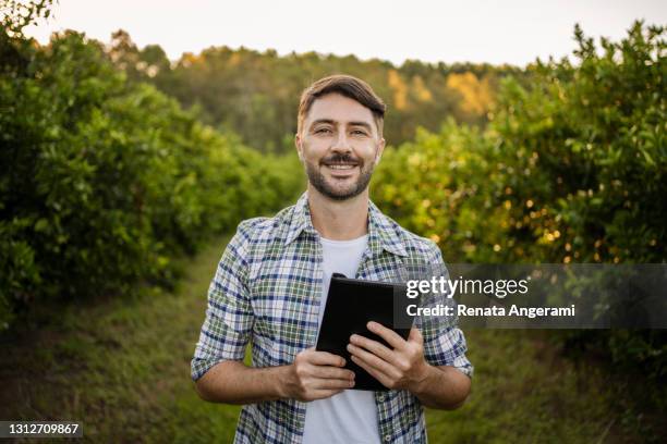 portrait of agricultural technician in orange plantation with tablet - farmer tablet stock pictures, royalty-free photos & images