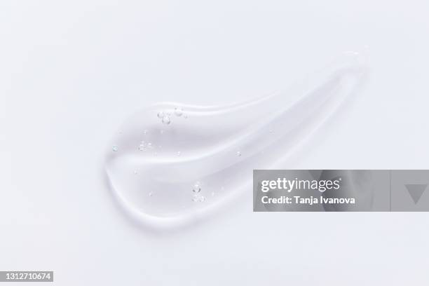 transparent smear of gel on white background. liquid hyaluronic acid gel. flat lay, top view, copy space - gel foto e immagini stock