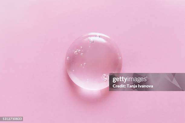 transparent drop of gel on a pink background. liquid hyaluronic acid gel. flat lay, top view, copy space. - duschgel nobody stock-fotos und bilder