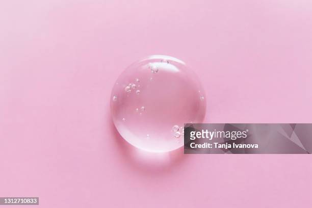 transparent drop of gel on a pink background. liquid hyaluronic acid gel. flat lay, top view, copy space. - gel stock pictures, royalty-free photos & images