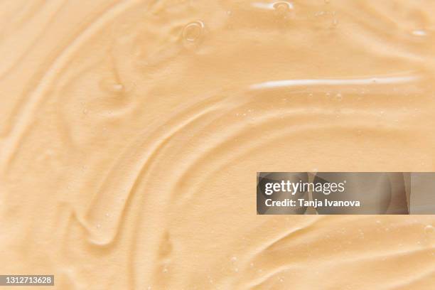 transparent gel with bubbles close-up on beige background. texture of gel cream. liquid hyaluronic acid gel. - face serum stock pictures, royalty-free photos & images