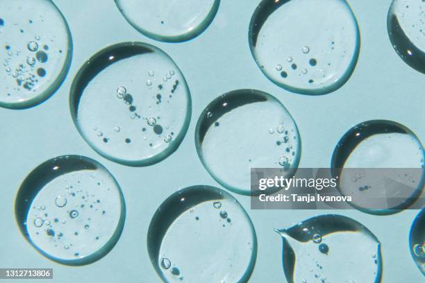 drops of natural moisturizing gel on blue background. flat lay, top view. skincare beauty product - facial cleanser stockfoto's en -beelden