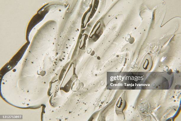 transparent gel cream cosmetic with bubbles on beige background. liquid hyaluronic acid gel. flat lay, top view. - haargel stock-fotos und bilder