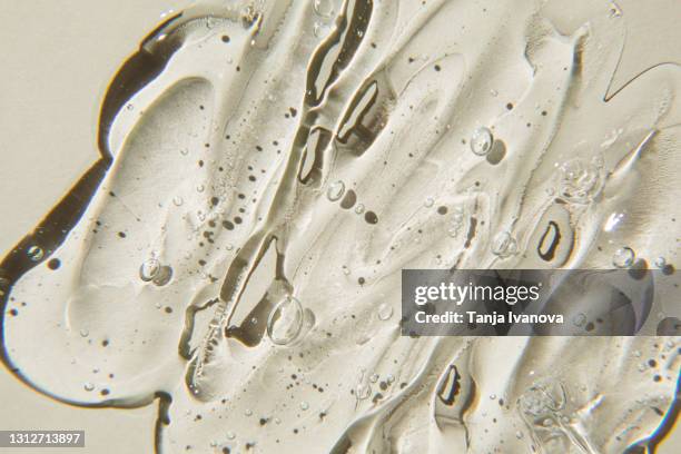 transparent gel cream cosmetic with bubbles on beige background. liquid hyaluronic acid gel. flat lay, top view. - duschgel nobody stock-fotos und bilder