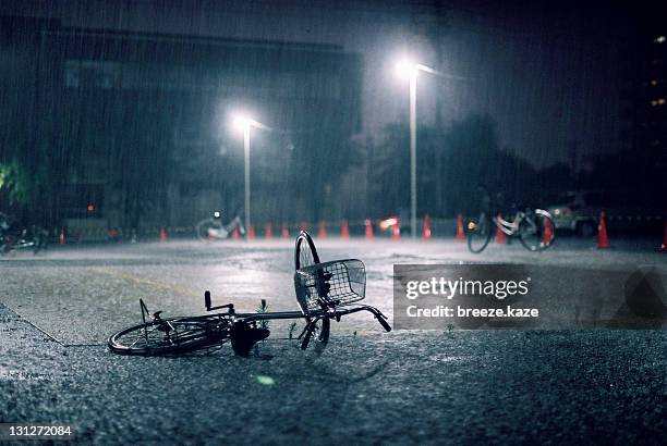 fallen bicycle in heavy rain. - absentie stockfoto's en -beelden