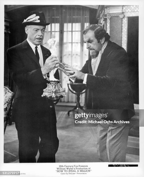 Fernand Gravet holds a forged Cellini statue to an apprehensive Hugh Griffith in a scene from the film 'How To Steal A Million', 1966.