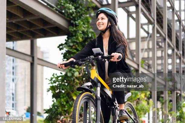 riding electric bicycle to work. - ebike stock pictures, royalty-free photos & images