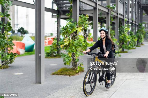 jeune femme allant travailler sur le vélo électrique. - biker photos et images de collection