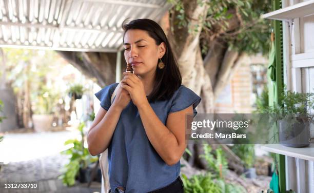 jeune femme sentant l’huile essentielle dans la tente extérieure - aromatherapy photos et images de collection