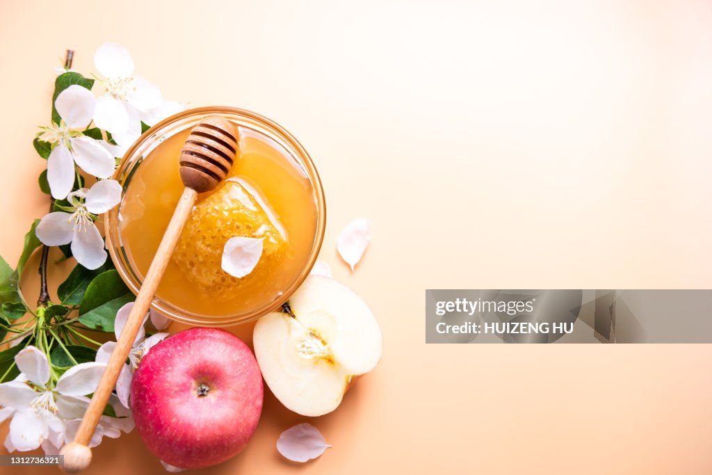 Honey with apple on yellow background