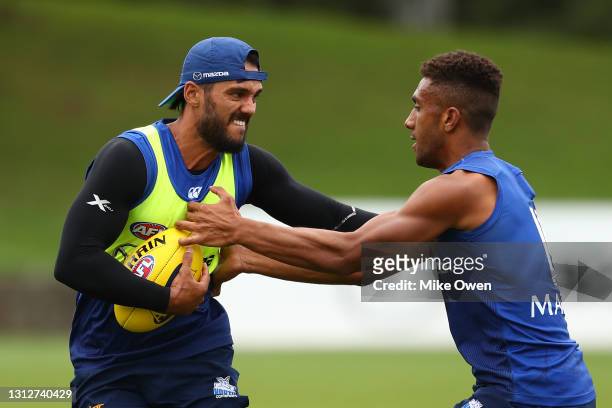 Aaron Hall of the Kangaroos is tackled during a North Melbourne Kangaroos AFL training session at Arden Street Ground on April 16, 2021 in Melbourne,...