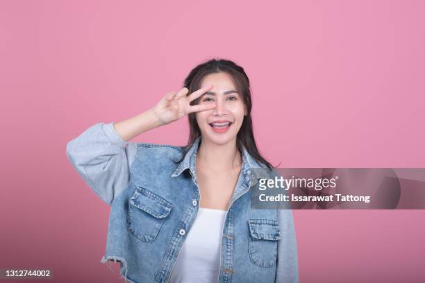 open mouth people person entertainment concept. close up portrait of playful excited funny joyful positive optimistic with toothy smile girl showing v-sign isolated on pink background copy-space - human finger stock pictures, royalty-free photos & images